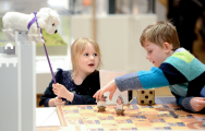 a boy and a girl playing with toys on a board